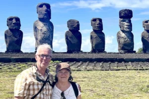 A couple of visitors in front of the Moai statues of Rapa Nui.